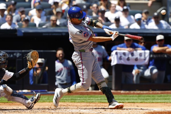 New York Mets' Mark Vientos (27) hits a sacrifice fly that that scored Juan Soto during the fourth inning of a baseball game against the New York Yankees, Saturday, May 17, 2025, in New York. (AP Photo/Noah K. Murray)