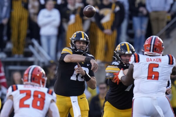 Iowa quarterback Deacon Hill (10) throws a pass during the first half of an NCAA college football game against Illinois, Saturday, Nov. 18, 2023, in Iowa City, Iowa. (AP Photo/Charlie Neibergall)