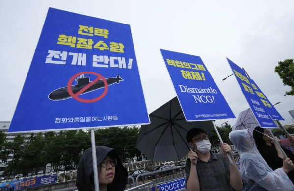 Protesters stage a rally against a meeting of Nuclear Consultative Group between South Korea and the United States in front of the presidential office in Seoul, South Korea, Tuesday, July 18, 2023. A bilateral consulting group of South Korean and U.S. officials met Tuesday in Seoul to discuss strengthening their nations' deterrence capabilities against North Korea's evolving nuclear threats. The signs read "Opposition to the deployment of nuclear submarine." (AP Photo/Ahn Young-joon)