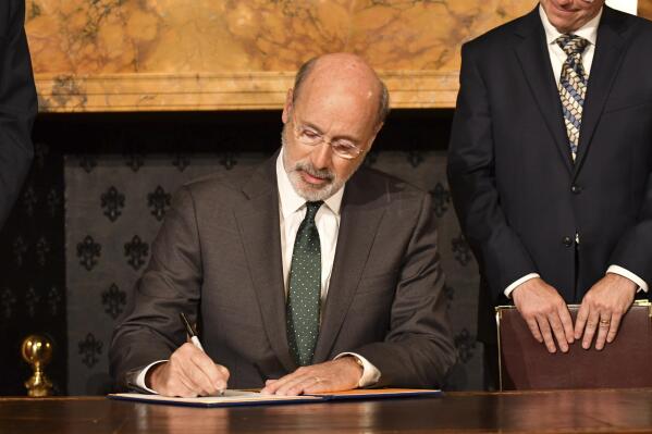 Pennsylvania Gov. Tom Wolf signs an executive order for his administration to start working on regulations to bring Pennsylvania into a nine-state consortium that sets a price and limits on greenhouse gas emissions from power plants, Thursday, Oct. 3, 2019 in Harrisburg, Pa. The move is part of Wolf's effort to fight climate change in the nation's fourth-biggest emitter of greenhouse gases. (AP Photo/Marc Levy)