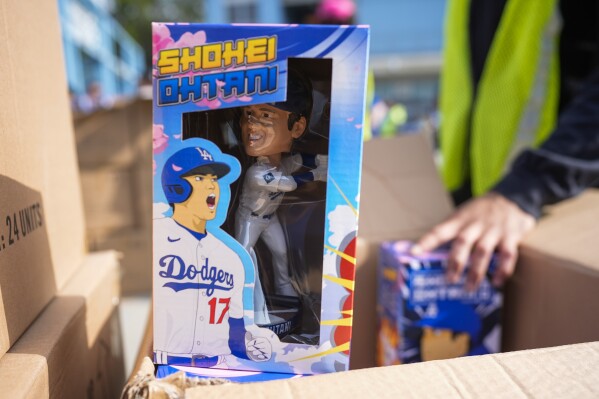 Bobbleheads of Los Angeles Dodgers designated hitter Shohei Ohtani are given to fans before a baseball game against the Cincinnati Reds in Los Angeles, Thursday, May 16, 2024. (Ǻ Photo/Ashley Landis)