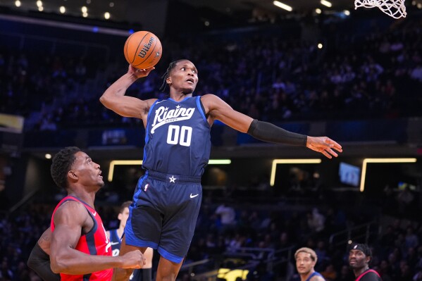 Bennedict Mathurin of the Indiana Pacers goes up for a dunk over Jalen Duren of the Detroit Pistons during an NBA Rising Stars basketball game in Indianapolis, Friday, Feb. 16, 2024. (AP Photo/Michael Conroy)
