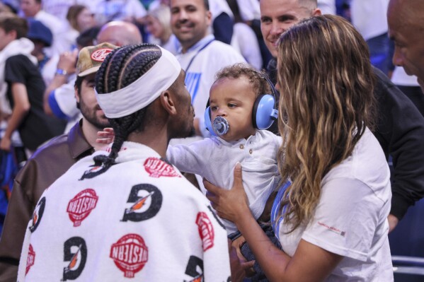 Oklahoma City Thunder guard Shai Gilgeous-Alexander, left, meets with his wife, Hailey Summers, and their son Ares Alexander following Game 1 of an NBA basketball Western Conference Finals playoff series against the Minnesota Timberwolves Tuesday, May 20, 2025, in Oklahoma City. (AP Photo/Nate Billings)