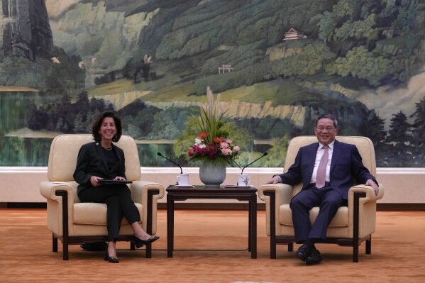 U.S. Commerce Secretary Gina Raimondo, left, and Chinese Premier Li Qiang have a light moment during a meeting at the Great Hall of the People in Beijing, Tuesday, Aug. 29, 2023. (AP Photo/Andy Wong, Pool)