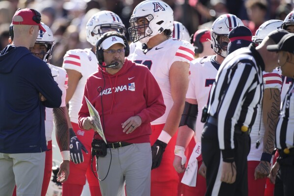 Arizona head coach Jedd Fisch, front center, looks on in the first half of an NCAA college football game against Colorado on Saturday, Nov. 11, 2023, in Boulder, Colo. (AP Photo/David Zalubowski)