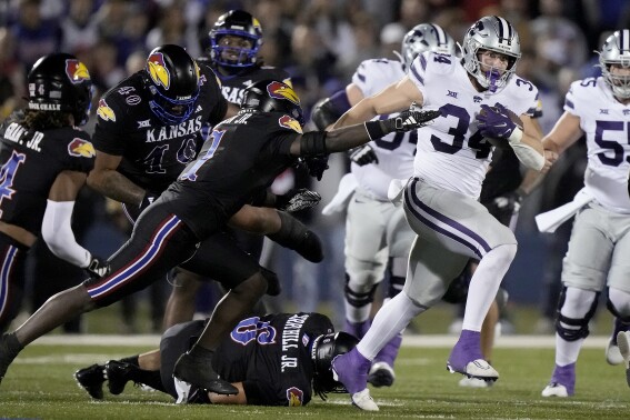 Kansas State tight end Ben Sinnott (34) is chased by Kansas safety Kenny Logan Jr. (1) during the first half of an NCAA college football game Saturday, Nov. 18, 2023, in Lawrence, Kan. (AP Photo/Charlie Riedel)