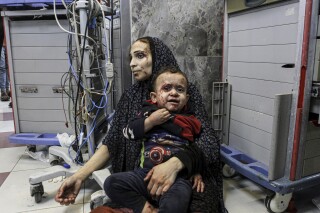 Wounded Palestinians wait for treatment in al-Shifa hospital in Gaza City, central Gaza Strip, after arriving from al-Ahli hospital following an explosion there, Tuesday, Oct. 17, 2023. The Hamas-run Health Ministry says an Israeli airstrike caused the explosion that killed hundreds at al-Ahli, but the Israeli military says it was a misfired Palestinian rocket. (AP Photo/Abed Khaled)