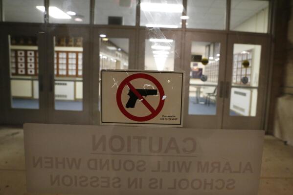 A no-gun sticker is displayed a doorway at Oak Park and River Forest High School on Thursday, Aug. 25, 2022, in Oak Park, Ill. Despite laws banning guns from schools, educators in cities, suburbs and rural areas say keeping guns out of schools is difficult. (AP Photo/Martha Irvine)