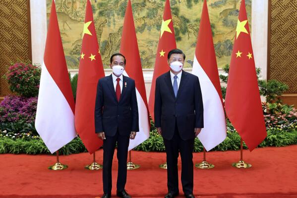 In this photo released by China's Xinhua News Agency, Indonesian President Joko Widodo, left, and Chinese President Xi Jinping, right, pose for a photo during a meeting at the Diaoyutai State Guesthouse in Beijing, Tuesday, July 26, 2022. Widodo on Tuesday formally invited Xi Jinping to the Group of 20 summit in Bali this fall, although it's unclear whether the Chinese leader would attend in person. (Pang Xinglei/Xinhua via AP)