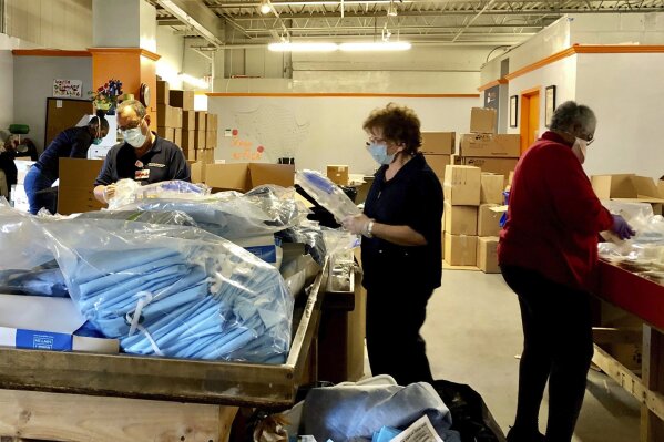 In this April 15, 2020 photo provided by the Afya Foundation, four volunteer retired nurses count and box donated sterile surgical gowns for distribution to New York City metro area hospitals, federally qualified health centers, and community agencies at the Afya Foundation warehouse in Yonkers, N.Y. (Mary Grace Padaguan/Afya Foundation via AP)
