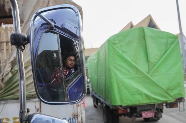 A Myanmar’s truck driver is reflected on a mirror as his truck carrying aid leaves at a customs checkpoint near the border with Myanmar, in Mae Sot, Tak province Thailand Monday, March 25, 2024. Thailand delivered its first batch of humanitarian aid to war-torn Myanmar sending ten trucks over the border from the northern province of Tak in what they hope will be a continuing effort to ease the plight of millions of people displaced by fighting. (AP Photo/Sakchai Lalit)