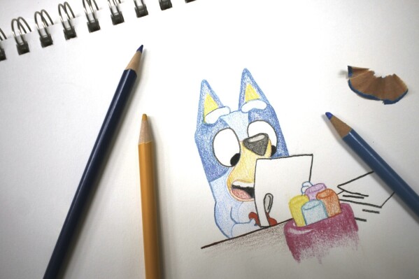 Colored pencils sit around a drawing of "Bluey" the Australian kids' television program character on a sketch pad Friday, April 19, 2024, in Phoenix, Ariz. (AP Photo/Cheyanne Mumphrey)