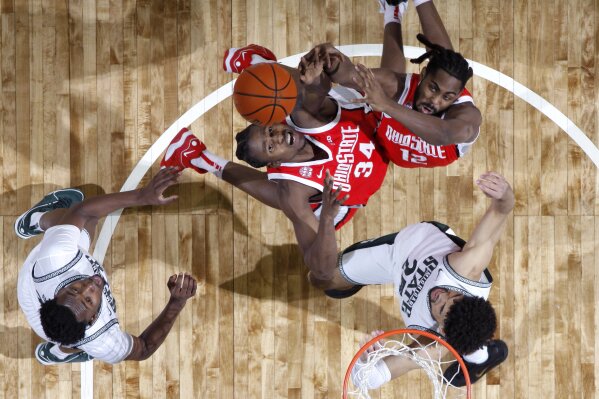 From left, Michigan State forward Xavier Booker, Ohio State center Felix Okpara (34), Ohio State guard Evan Mahaffey (12) and Michigan State forward Malik Hall (25) vie for a rebound during the second half of an NCAA college basketball game, Sunday, Feb. 25, 2024, in East Lansing, Mich. (AP Photo/Al Goldis)