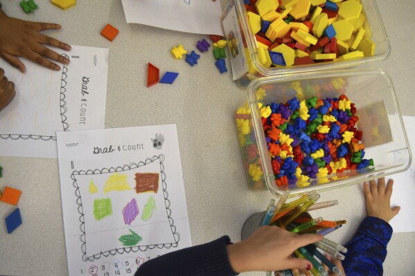 Preschool students practice math using manipulatives at a public school in Boston in 2016. Experts say all students, not only those with dyscalculia, could benefit from using manipulatives to help visualize problems and graph paper to assist in lining up numbers. (Lillian Mongeau/The Hechinger Report via AP)