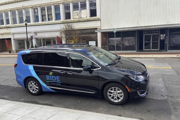 This photo provided by the city of Wilson, N.C., shows a RiDE van parked on the city street in Wilson, N.C. The city of Wilson, North Carolina, ended its bus service in September 2020 to offer on-demand van trips anywhere in town for less than $3 a ride. Even during the pandemic, which sent public transit ridership plummeting, it surged 300% in Wilson. ( City of Wilson, N.C. via AP)