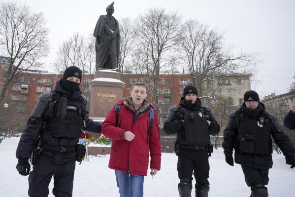 Policemen detain a man who has laid flowers to the monument of Ukrainian author Taras Shevchenko to mark one year since the start of the Russian campaign in Ukraine in St. Petersburg, Russia, Friday, Feb. 24, 2023. OVD-Info, a group that tracks political arrests, said that several people were detained in St. Petersburg after bringing flowers to the Shevchenko monument. (AP Photo/Dmitri Lovetsky)