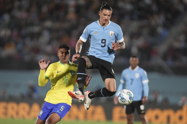 Uruguay's Darwin Nunez jumps for a ball challenged by Brazil's Casemiro during a qualifying soccer match for the FIFA World Cup 2026 at Centenario stadium in Montevideo, Uruguay, Tuesday, Oct. 17, 2023. (AP Photo/Matilde Campodonico)