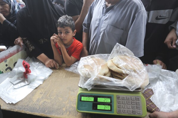 Palestinians wait to buy bread during the ongoing bombardment of the Gaza Strip in Rafah on Sunday, Oct. 29, 2023. (AP Photo/Hatem Ali)