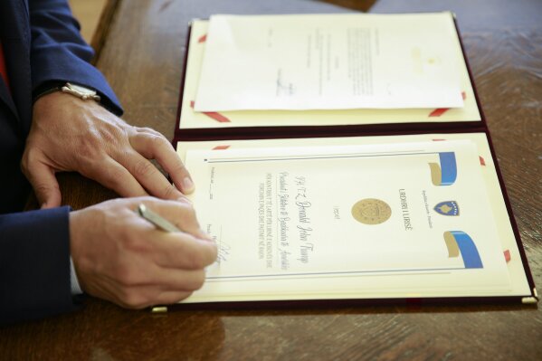 Kosovo's President Hashim Thaci signs the Order of Freedom awarded to U.S President Donald Trump, in capital Pristina, Kosovo on Friday, Sept. 18, 2020. Kosovo's president awarded U.S. President Donald Trump with one of the country's highest medals - Kosovo's Order of Freedom - for his government's efforts on peace and reconciliation in the former war-torn region. (AP Photo/Visar Kryeziu)