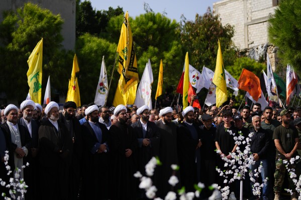 Muslim Shiite clerics and supporters attend the funeral procession of Hezbollah fighter, Bilal Nemr Rmeiti, who was killed by Israeli shelling, during his funeral procession in Majadel village, south Lebanon, Sunday, Oct. 22, 2023. (AP Photo/Hassan Ammar)