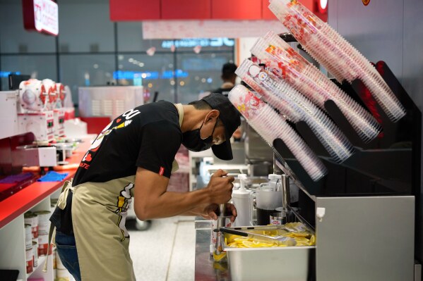 A Mixue outlet staff prepares drink for customer at a shopping outlet in Sepang, Malaysia, Thursday, March 25, 2025. (AP Photo/Vincent Thian)