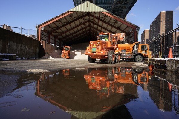 FILE — New York City Sanitation Department workers use a front-end loader to to fill a salt spreader at one of the Department's salt sheds in lower Manhattan, Jan. 7, 2022, in New York. Parts of the Northeast were preparing Monday, Feb. 12, 2024 for a coastal storm that was expected to pack high winds and dump a foot or more of snow in some areas, leading to school closures, warnings against traveling by road and the possible disruption of flights. (AP Photo/Mary Altaffer, File) )