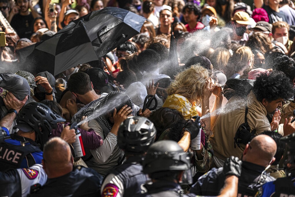 Police pepper spray pro-Palestinian protesters blocking police vehicles from leaving the University of Texas in Austin, Texas, Monday, April 29, 2024. (Aaron E. Martinez/Austin American-Statesman via AP)