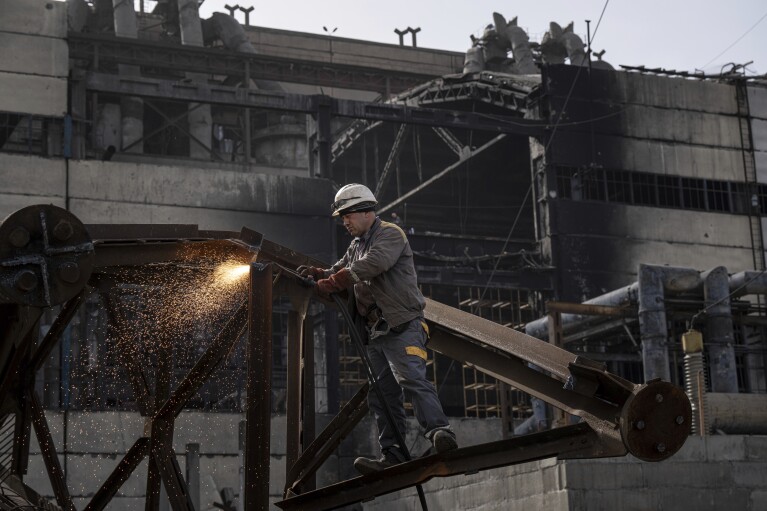 A worker cuts metal after a Russian missile attack at DTEK's power plant in Ukraine, on Monday, April 1, 2024. Russia is attacking Ukraine’s energy sector with renewed intensity and alarming accuracy, signaling to Ukrainian officials that Russia is armed with better intelligence and fresh tactics in its campaign to annihilate the country’s power generation capacity. (AP Photo/Evgeniy Maloletka)
