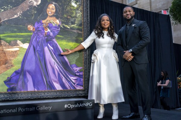 Oprah Winfrey and artist Shawn Michael Warren pose together next to Warren's portrait of Winfrey, Wednesday, Dec. 13, 2023, during a portrait unveiling ceremony at the Smithsonian's National Portrait Gallery in Washington. (AP Photo/Jacquelyn Martin)