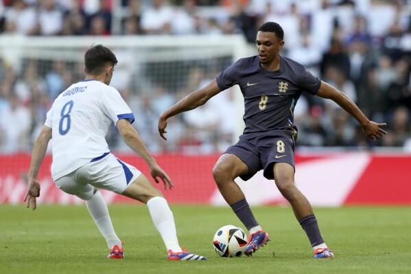 England's Trent Alexander Arnold tries to dribble the ball past Bosnia and Herzegovina's Armin Gigovic, left, during an international friendly soccer match between England and Bosnia and Herzegovina at St. James Park in Newcastle, England, Monday, June 3, 2024. (AP Photo/Scott Heppell)