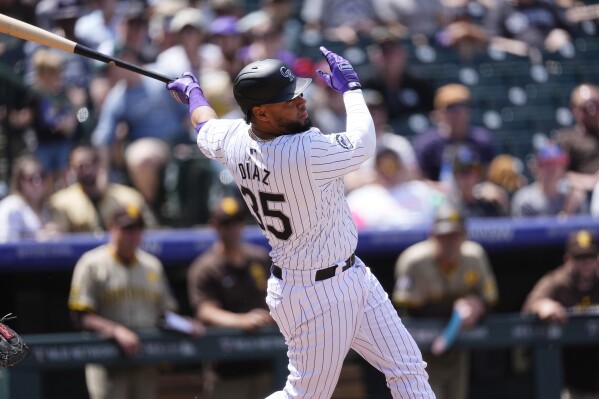 Colorado Rockies' Elias Díaz follows the flight of his sacrifice fly to drive in a run off San Diego Padres starting pitcher Randy Vásquez in the first inning of a baseball game Thursday, April 25, 2024, in Denver. (AP Photo/David Zalubowski)