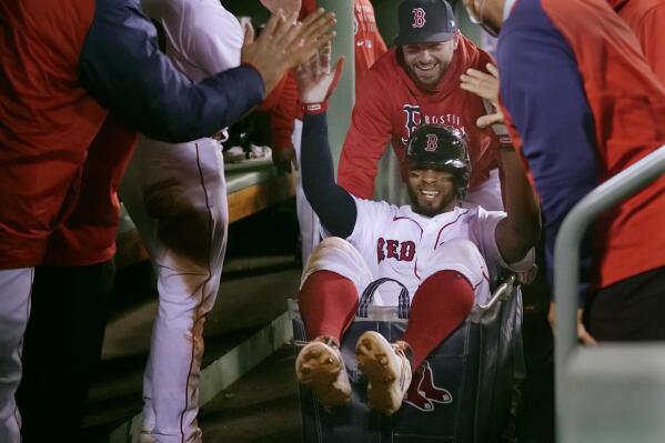 FILE - In this May 4, 2021, file photo, Boston Red Sox's Xander Bogaerts high-fives teammates while being pushed in a laundry cart through the dugout after his two-run home run against the Detroit Tigers during the second inning of a baseball game at Fenway Park in Boston. Started on a lark in a last-place season, the Red Sox have continued the celebration this year and ridden it all the way to a playoff berth, a win over the rival New York Yankees in the AL wild-card game and then a four-game victory over Tampa Bay in the Division Series. (AP Photo/Charles Krupa, File)