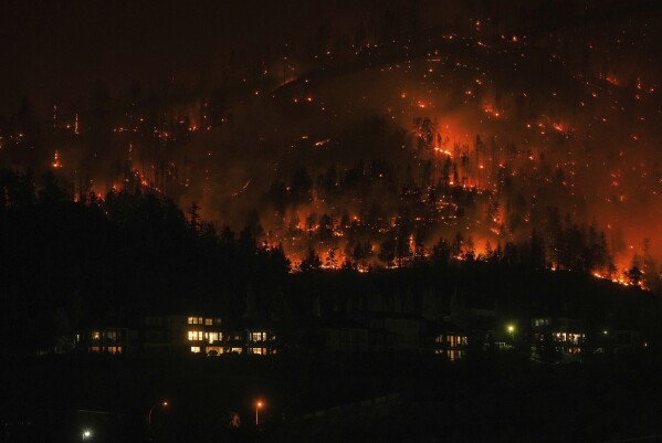The McDougall Creek wildfire burns on the mountainside above houses in West Kelowna, British Columbia, on Aug. 18, 2023. (Darryl Dyck/The Canadian Press via AP)