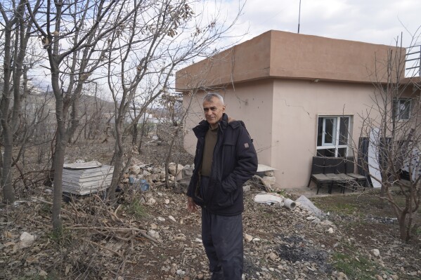 Farooq Safar standing in his back yard that was bombed by a Turkish drone in October 2024. Guharze village in Dahuk, Iraq, Thursday, Feb. 27, 2025. (AP Photo/Rashid Yahya)