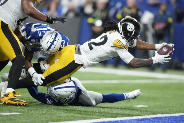 Pittsburgh Steelers' Najee Harris (22) dives in for a touchdown against Indianapolis Colts' Julian Blackmon (32) and Kenny Moore II (23) during the first half of an NFL football game, Monday, Nov. 28, 2022, in Indianapolis. (AP Photo/Michael Conroy)
