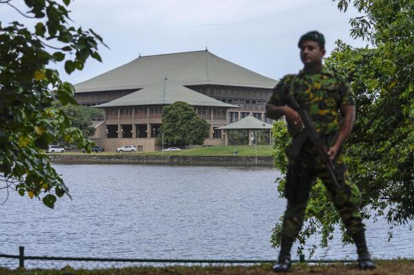 FILE- An army soldier soldier stands guard outside the parliament building in Colombo, Sri Lanka, Saturday, July 16, 2022. Sri Lankan lawmakers began debating a proposed constitutional amendment on Thursday that would trim the powers of the president, a key demand of protesters who are seeking political reforms and solutions to the country’s dire economic crisis. The bill will be debated on Thursday, Oct. 20, and Friday and a vote will be held on Friday. It must be approved by two-thirds of the 225-member Parliament to become law. (AP Photo/Rafiq Maqbool, File)