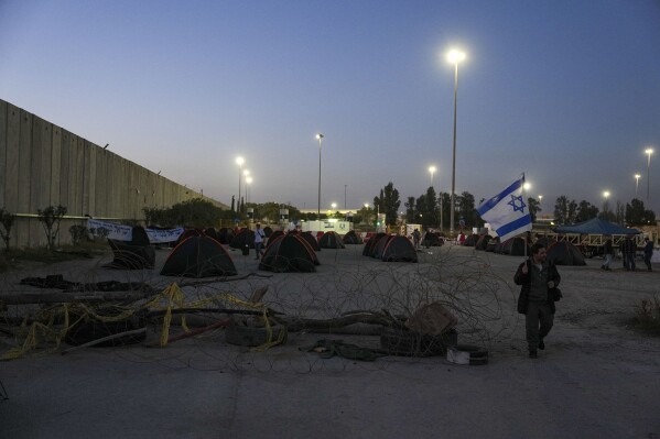 Israeli activists set up tents for blocking trucks carrying humanitarian aid into the Gaza Strip at the Kerem Shalom border crossing between Israel and Gaza, in southern Israel, Wednesday, Feb. 7, 2024. The activists say no aid should enter the territory until Israeli hostages held captive by the Hamas militant group are released. (AP Photo/Tsafrir Abayov)