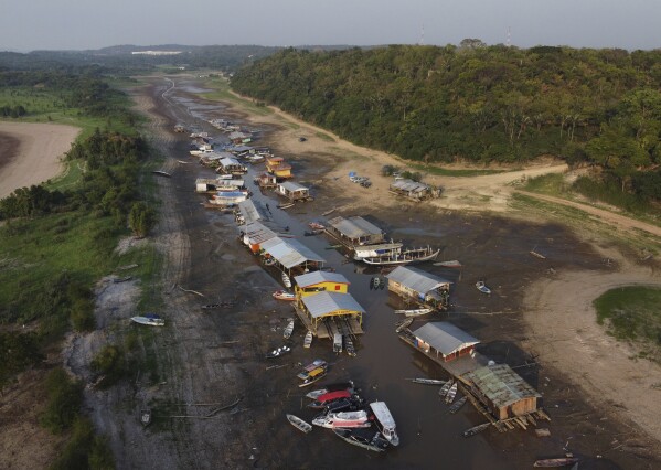 FILE - Floating homes and boats lay stranded on the dry bed of Puraquequara lake, amid a severe drought, in Manaus, Amazonas state, Brazil, Oct. 5, 2023. The extreme drought sweeping across Brazil’s Amazon rainforest is already impacting hundreds of thousands of people and killing local wildlife. (AP Photo/Edmar Barros, File)