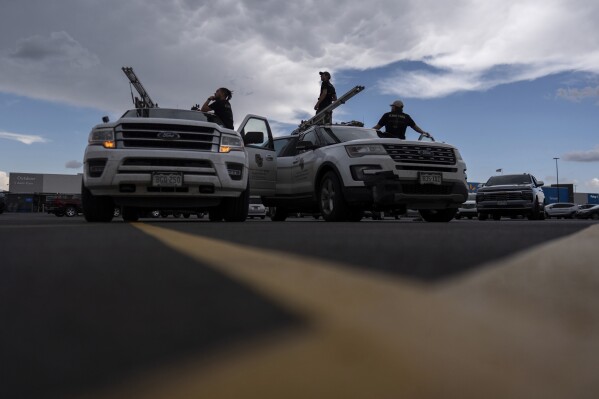 Members of the University of Colorado Boulder's Integrated Remote and In-Situ Sensing flight team stage in a Walmart parking lot before a Project ICECHIP operation Tuesday, June 3, 2025, in Atlus, Okla. (AP Photo/Carolyn Kaster)