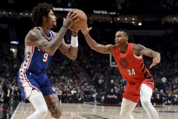 CORRECTS TO 2024 NOT 2023 - Philadelphia 76ers guard Kelly Oubre Jr. left, looks to get past Portland Trail Blazers forward Jabari Walker, right, during the first half of an NBA basketball game in Portland, Ore., Monday, Jan. 29, 2024. (AP Photo/Steve Dykes)