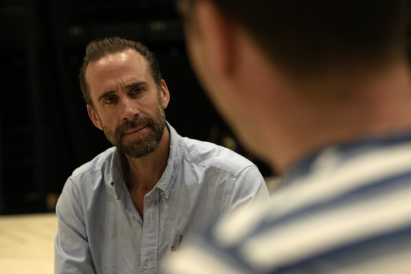 Actor Joseph Fiennes, left, and writer James Graham on stage as they look at the script for the play based around the England soccer manager Gareth Southgate entitled 'Dear England' at the productions rehearsal studio in London, Wednesday, Sept. 20, 2023. Outside of families, few relationships are as intense as those between sports teams and their fans. In the case of England’s bond with its national team, it’s not always been healthy. James Graham’s play “Dear England” looks at the state of the nation through the ups and downs of England’s men’s soccer team. (AP Photo/Alastair Grant)