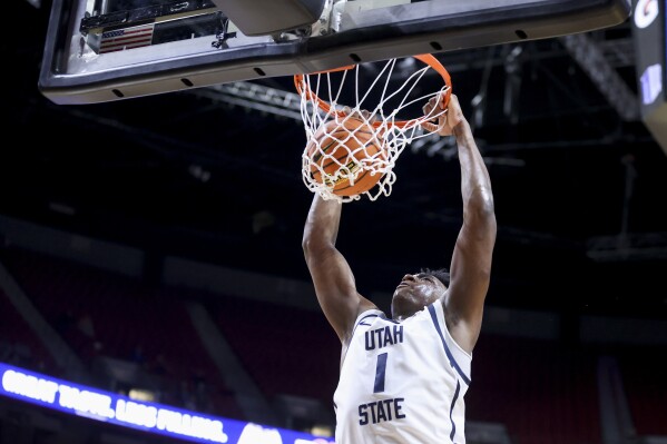Utah State forward Great Osobor (1) dunks against Fresno State during the first half of an NCAA college basketball game in the quarterfinal round of the Mountain West Conference tournament, Thursday, March 14, 2024, in Las Vegas. (AP Photo/Ian Maule)