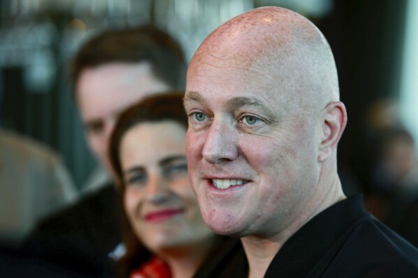 New Zealand National Party leader and Prime MInister elect Christopher Luxon, right, comments to media in Auckland, Sunday, Oct. 15, 2023, following his victory in a national election on Saturday. (Alex Burton/New Zealand Herald via AP)