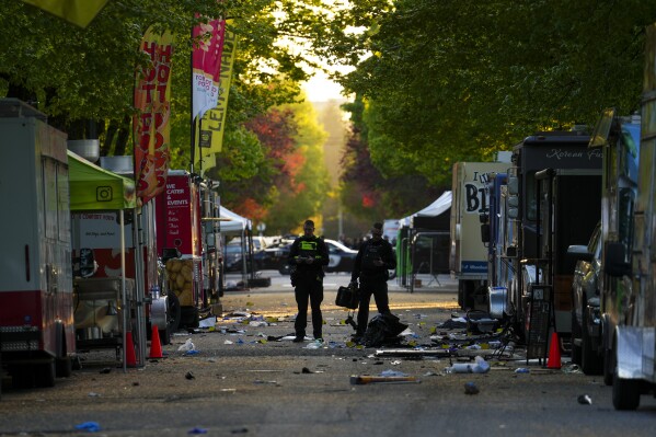 Members of the Vancouver Police forensics team examines the scene where a vehicle drove into a crowd during a Filipino heritage festival in Vancouver, British Columbia, Sunday, April 27, 2025. (Sean Kilpatrick/The Canadian Press via AP)