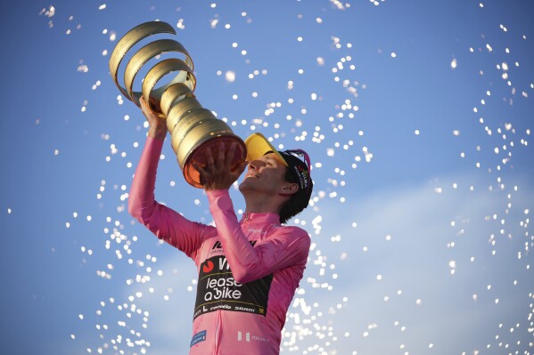 Britain's Simon Yates kisses the trophy after winning the Giro d'Italia cycling race, in Rome, Sunday, June 1, 2025. (AP Photo/Alessandra Tarantino)