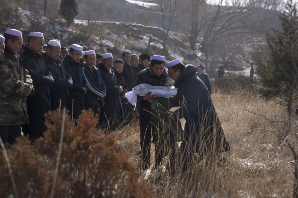 The body of a child who was killed in an earthquake is prepare for burial at a cemetery in Yangwa village near Dahejia town in northwestern China's Gansu province, Wednesday, Dec. 20, 2023. (AP Photo/Ng Han Guan)