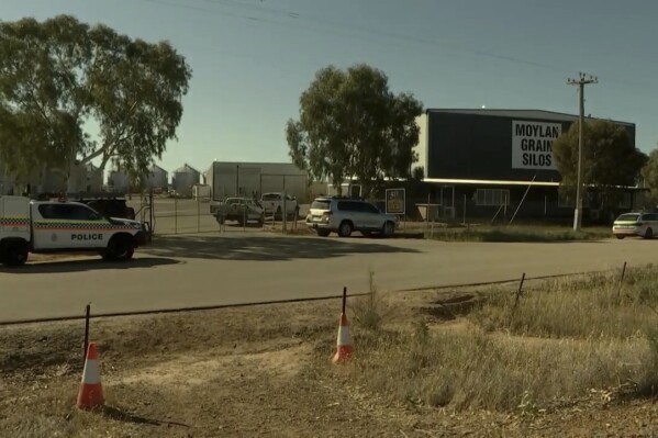 This image made from video provided by Australian Broadcasting Corporation shows Moylan Grain Silos site with police cars, following a shooting in Kellerberrin, Western Australia, Australia, Thursday, Sept. 7, 2023. Police said they were trying to persuade an alleged a gunman to surrender after a man was shot dead Thursday in the Western Australia state wheatbelt town.(Australian Broadcasting Corporation via AP)