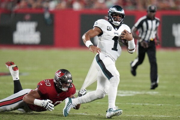 Philadelphia Eagles' Jalen Hurts (1) is tackled by Tampa Bay Buccaneers' Logan Hall (90) during the first half of an NFL football game, Monday, Sept. 25, 2023, in Tampa, Fla. (AP Photo/Chris O'Meara)