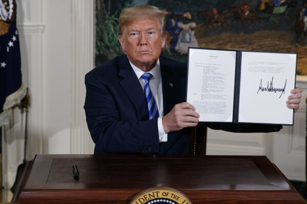 
              President Donald Trump shows a signed Presidential Memorandum after delivering a statement on the Iran nuclear deal from the Diplomatic Reception Room of the White House, Tuesday, May 8, 2018, in Washington. (AP Photo/Evan Vucci)
            