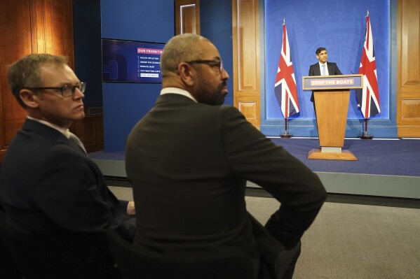FILE - Britain's Minister of State for Countering Illegal Migration Michael Tomlinson, left, and Home Secretary James Cleverly, attend a press conference in Downing Street, London, held by Britain's Prime Minister Rishi Sunak, on Jan. 18, 2024. The British government’s contentious plan to send some asylum-seekers on a one-way trip to Rwanda could cost nearly half a billion pounds ($630 million), plus hundreds of thousands per deportee, a report said Friday March 1, 2024. (Stefan Rousseau/Pool Photo via AP, File)
